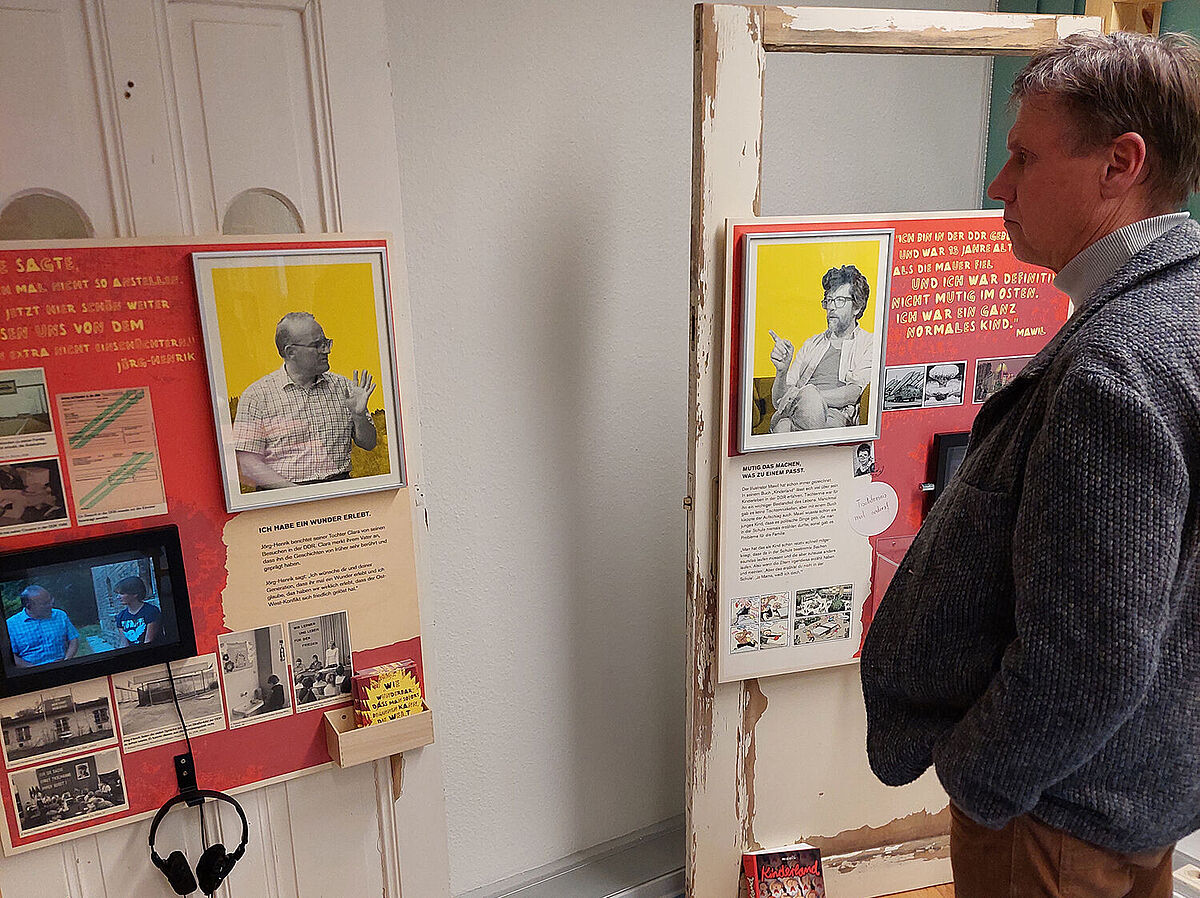 Ein Mann steht vor zwei Stelen mit Hörstationen in der interaktiven Wanderausstellung "Parole: Funkenschlagen!".