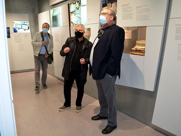 Der Berliner Aufarbeitungsbeauftragte Tom Sello, der Bundesbeauftragte Roland Jahn und der Präsident des Abgeordnetenhauses von Berlin, Ralf Wieland stehen in der Ausstellung "Einblick ins Geheime" und schauen auf eine Ausstellungstafel. Alle drei Männer tragen einen Mund-Nasen-Schutz.