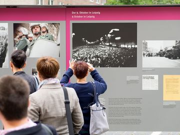 Die Gäste der Leipziger Delegation vor der Open-Air-Ausstellung „Revolution und Mauerfall“ auf dem Innenhof.
