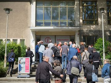 Eine Gruppe von Menschen geht in das Besucherzentrum in "Haus 22" auf dem Gelände der ehemaligen Stasi-Zentrale.
