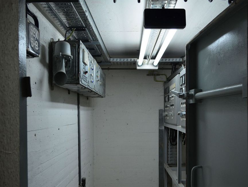 Blick in einen Raum des Bunkers unter "Haus 9" der ehemaligen Stasi-Zentrale. Der Raum enthält Reste von eingebauter Technik und Schaltschränken.