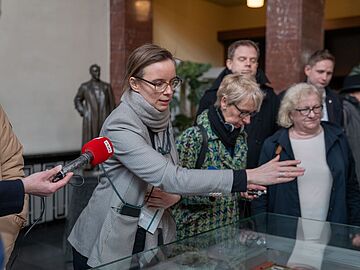 Eine Mitarbeiterin des Stasi-Unterlagen-Archivs führt Besucherinnen und Besucher durch das Stasimuseum.