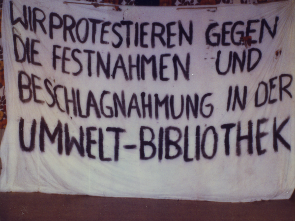 Beschlagnahmtes Transparent, das Demonstranten am Morgen des 27. November 1987 an den Turm der Zionskirche in Berlin gehängt hatten. Die Aufschrift lautet: „Wir protestieren gegen die Festnahmen und die Beschlagnahmung in der Umweltbibliothek“.