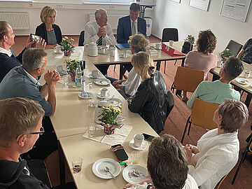 Joachim Gauck sitzt mit Mitarbeiterinnen und Mitarbeitern des Stasi-Unterlagen-Archivs Neubrandenburg an einem Tisch.