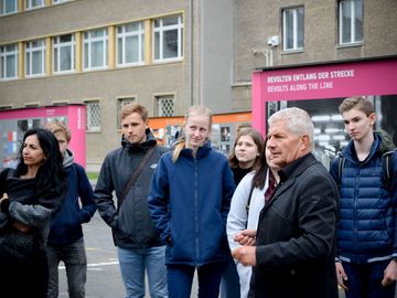 Der Bundesbeauftragte Roland Jahn mit Schülern in der Open-Air-Ausstellung "Revolution und Mauerfall" in der "Stasi-Zentrale. Campus für Demokratie".