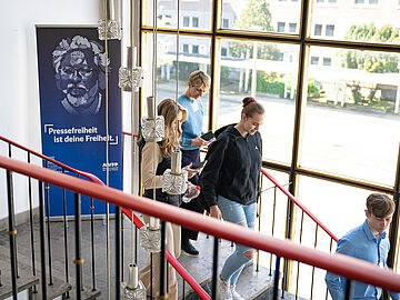 Schülerinnen und Schüler gehen am Tag der Pressefreiheit eine Treppe in "Haus 22" in der ehemaligen Stasi-Zentrale hinab.