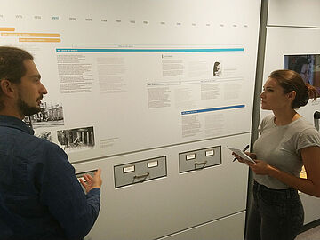 Ein Mitarbeiter des Stasi-Unterlagen-Archivs führt die amerikanische Doktorandin Lauren Cassidy durch die Ausstellung "Einblick ins Geheime".