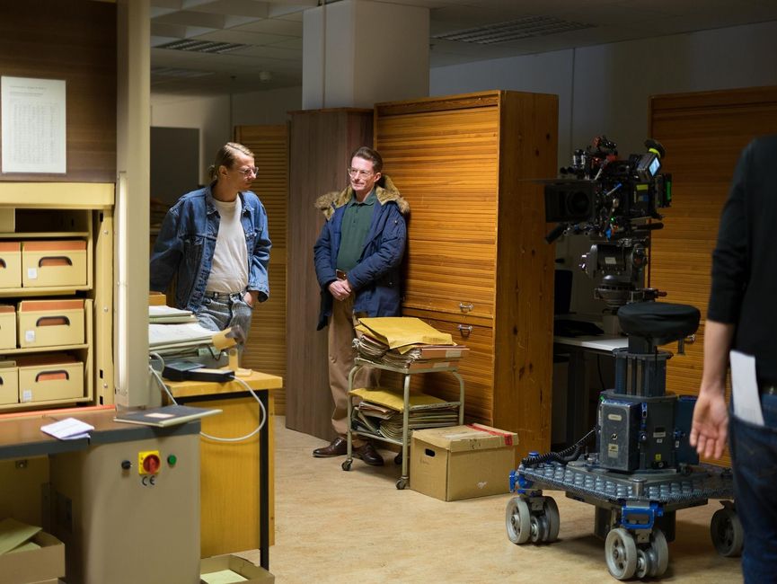 Das Bild zeigt einen Filmszene mit dem Gundermann-Darsteller Alexander Scheer in einem Büro.