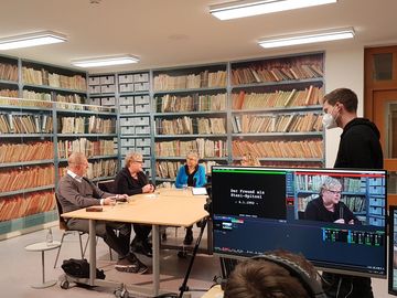 Im Hintergrund sind an einem Tisch sitzend Stefan Trobisch-Lütge, Evelyn Zupke​​​​​​​, Ulrike Poppe und Dagmar Hovestädt beim Gespräch zu sehen. Im Vordergrund befindet sich ein Monitor mit dem Aufnahmeprogramm.