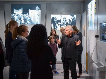 Der Bundesbeauftragte Roland Jahn und führt Schülerinnen und Schüler durch die Ausstellung "Einblick ins Geheime", die einen Blick in das Stasi-Unterlagen-Archiv, seine Aufgabe und seine Inhalte ermöglicht.