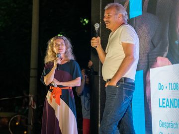 Dagmar Hovestädt und Leander Haußmann stehen mit Mikrofonen auf der Bühne des Campus-Kinos